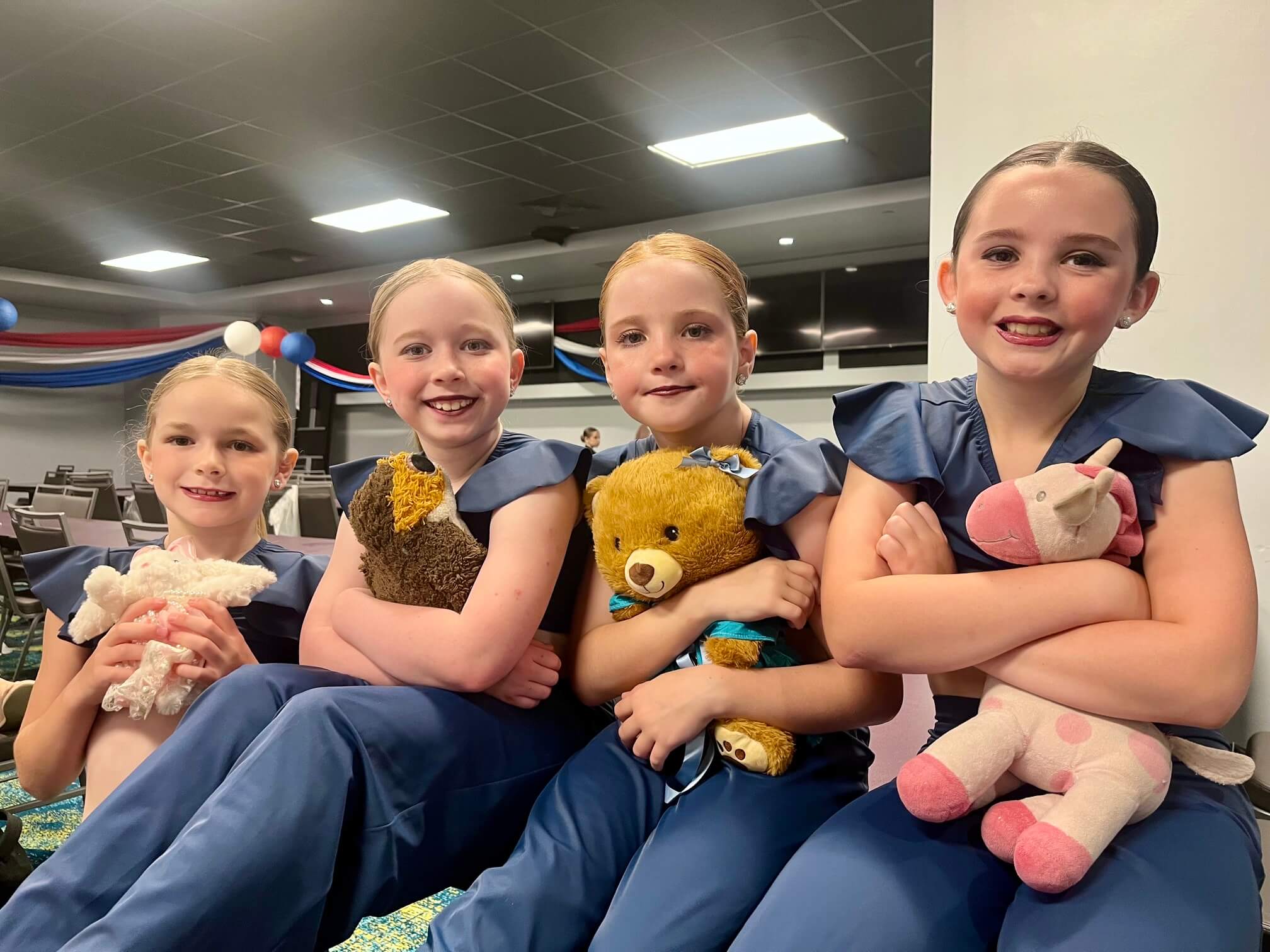 Kinetic Dance Force competition dancers smiling together backstage in matching costumes